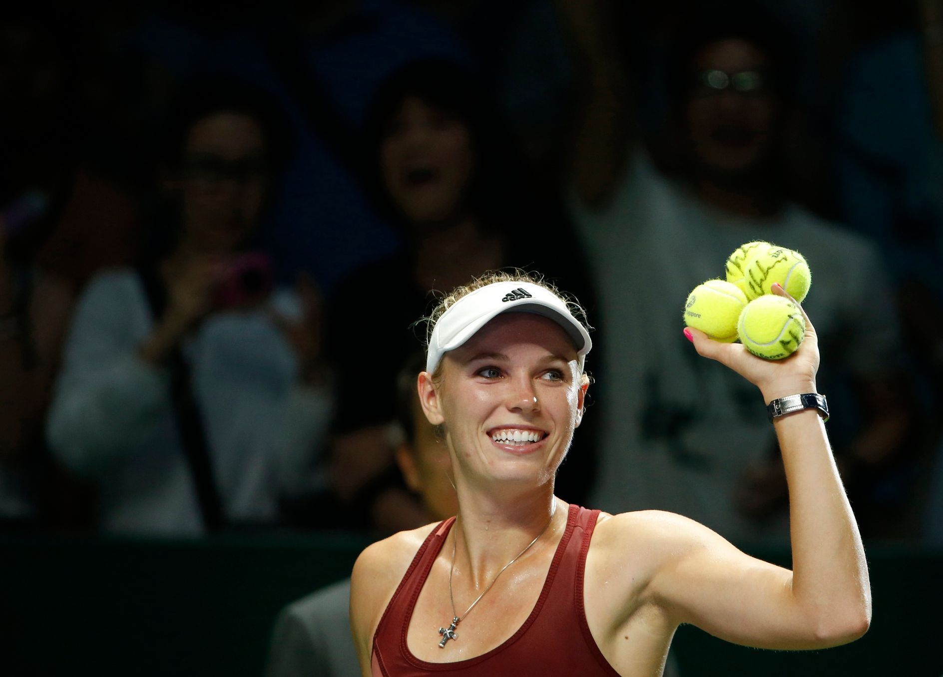 Wozniacki of Denmark prepares to hit balls to the audience after defeating Radwanska of Poland during their WTA Finals singles tennis match at the Singapore Indoor Stadium