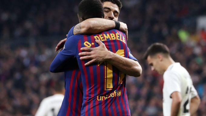 Zatímco hráči Realu klopí hlavy, hrdina duelu Luis Suárez přijímá gratulace od spoluhráče z Barcelony Ousmana Dembélého