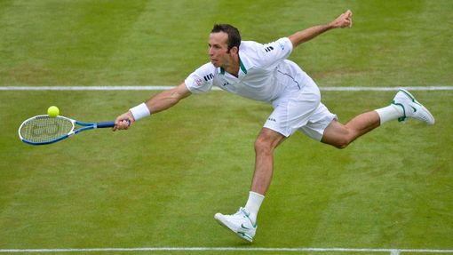 Český tenista Radek Štěpánek dobíhá míček během utkání s Ukrajincem Sergejem Stachovskym v 1. kole Wimbledonu 2012.