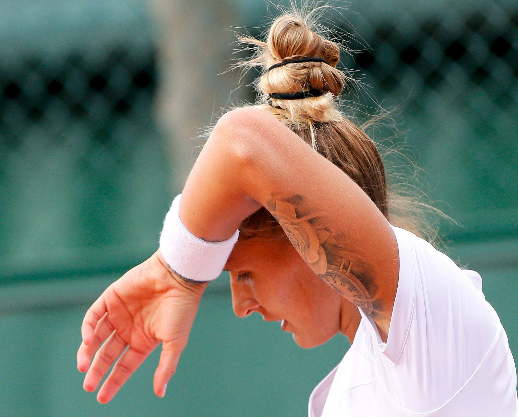 Polona Hercog of Slovenia wipes her face during the women's singles match against China's Peng Shuai at the French Open tennis tournament at the Roland Garros stadium in Paris