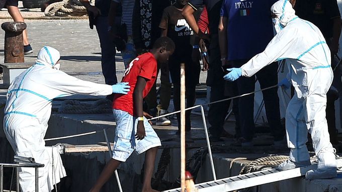 Migranti ze španělské lodi Open Arms vystupují na italském ostrově Lampedusa.