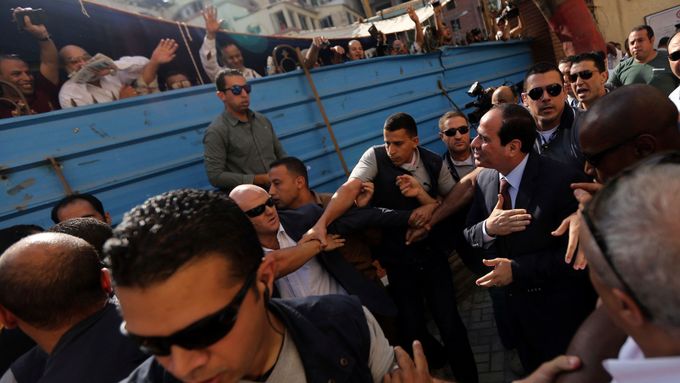 Sísí v kravatě zdraví lidi před volební místností v Káhiře.