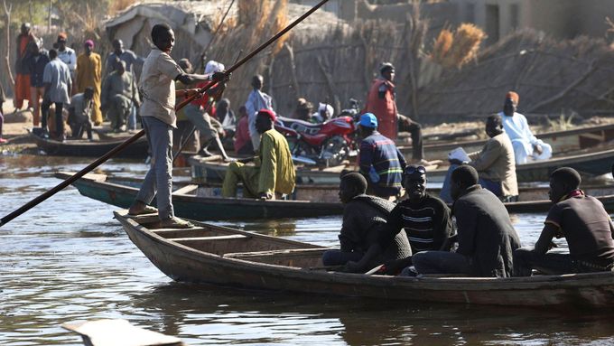 Lidé prchají před islamisty přes Čadské jezero.