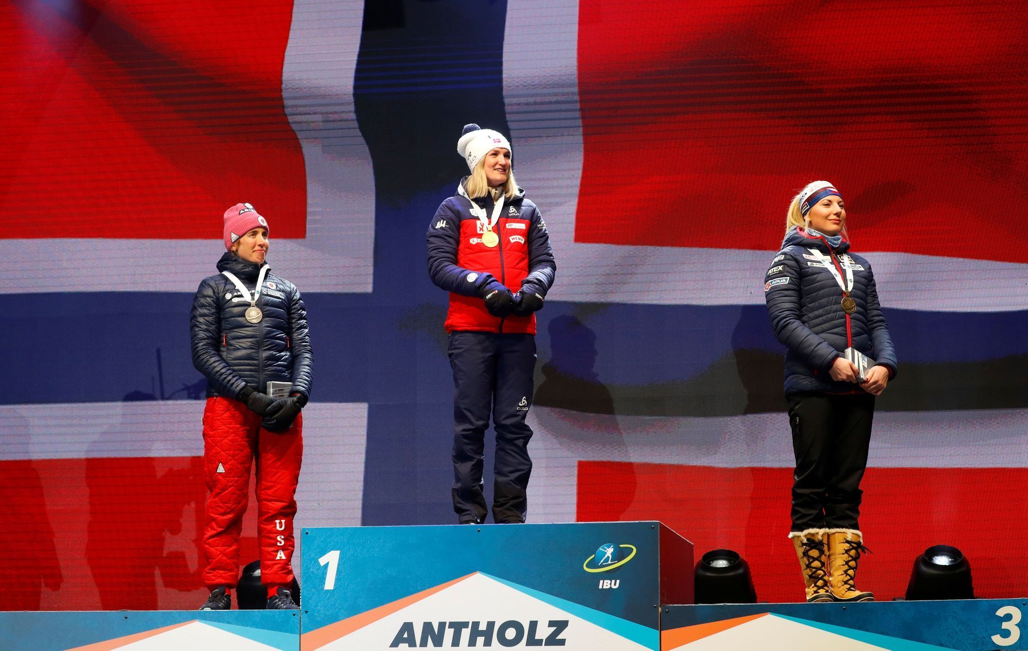 Susan Dunkleeová, Marte Olsbuová Röiselandová a Lucie Charvátová při ceremoniálu sprintu na MS 2020 v Anterselvě
