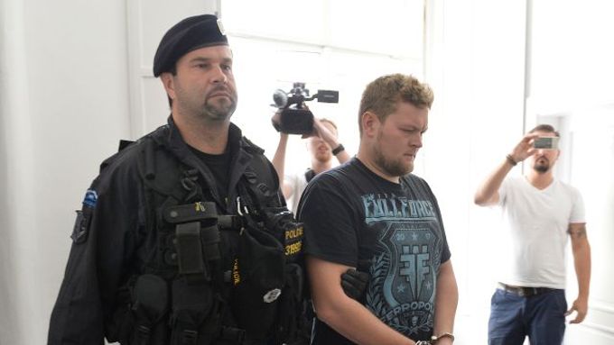 Policista přivádí  k pražskému obvodnímu soudu jednoho ze dvou cizinců, kteří posprejovali Karlův most.