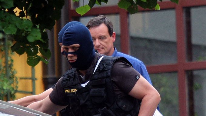 David Rath v obklíčení maskovaných policistů.