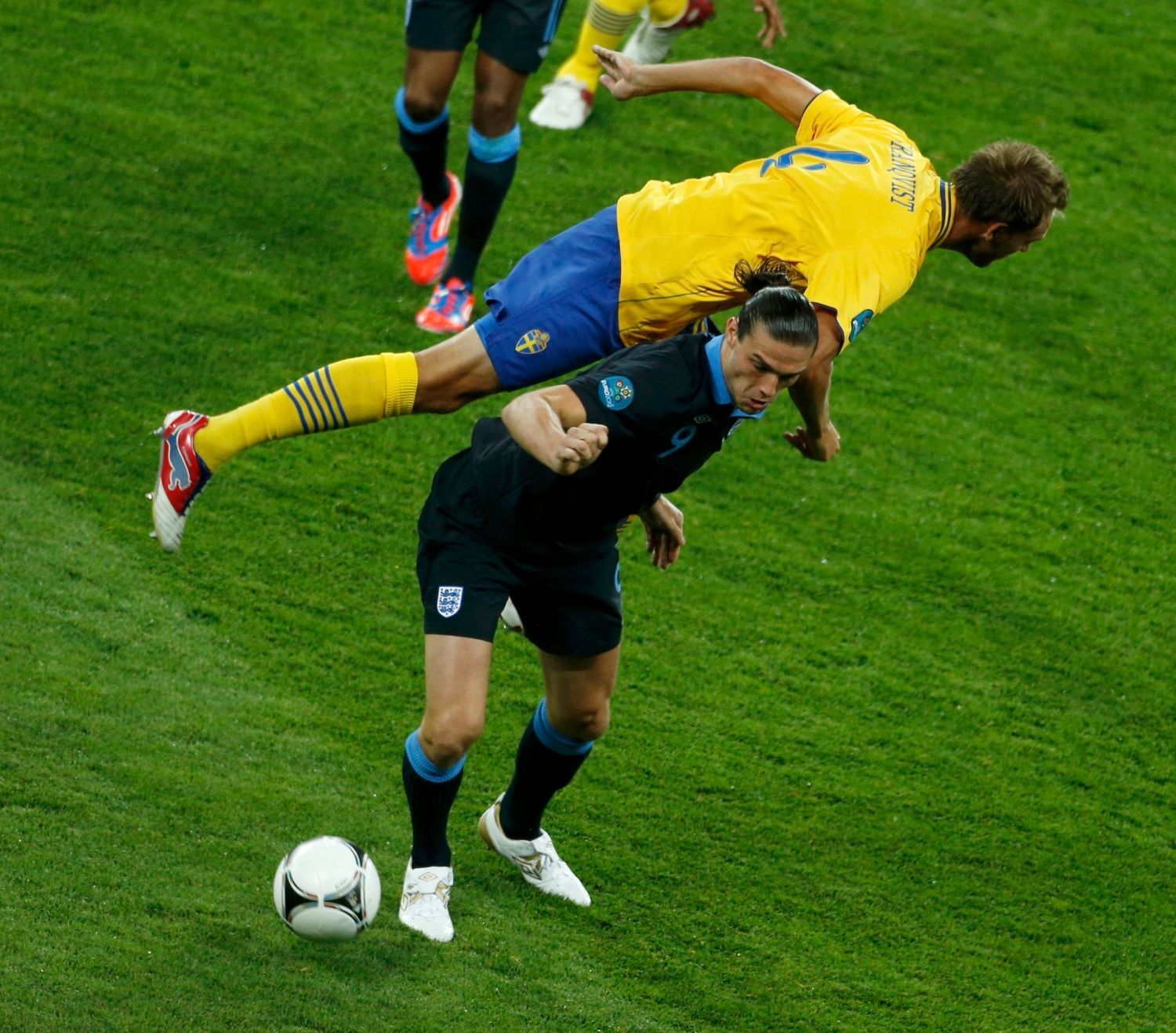 Švédský fotbalista Andreas Granqvist letí přes záda Angličana Theo Walcotta v utkání skupiny D na Euru 2012