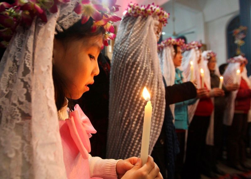 Malá Číňanka se modlí v Chang-čou, v provincii Če-ťiang.