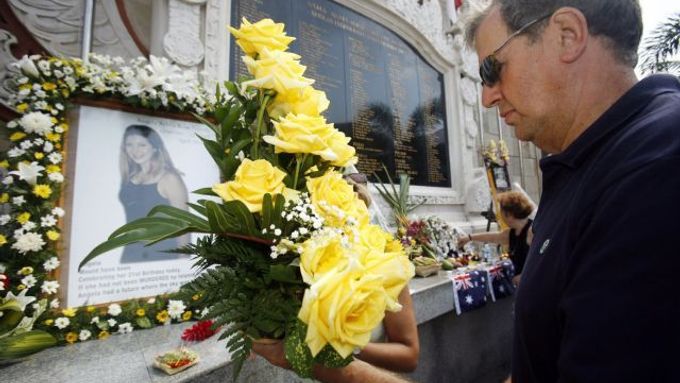 Příbuzní obětí výbuchů z 12. října 2002 kladou květiny k památníku na Bali.