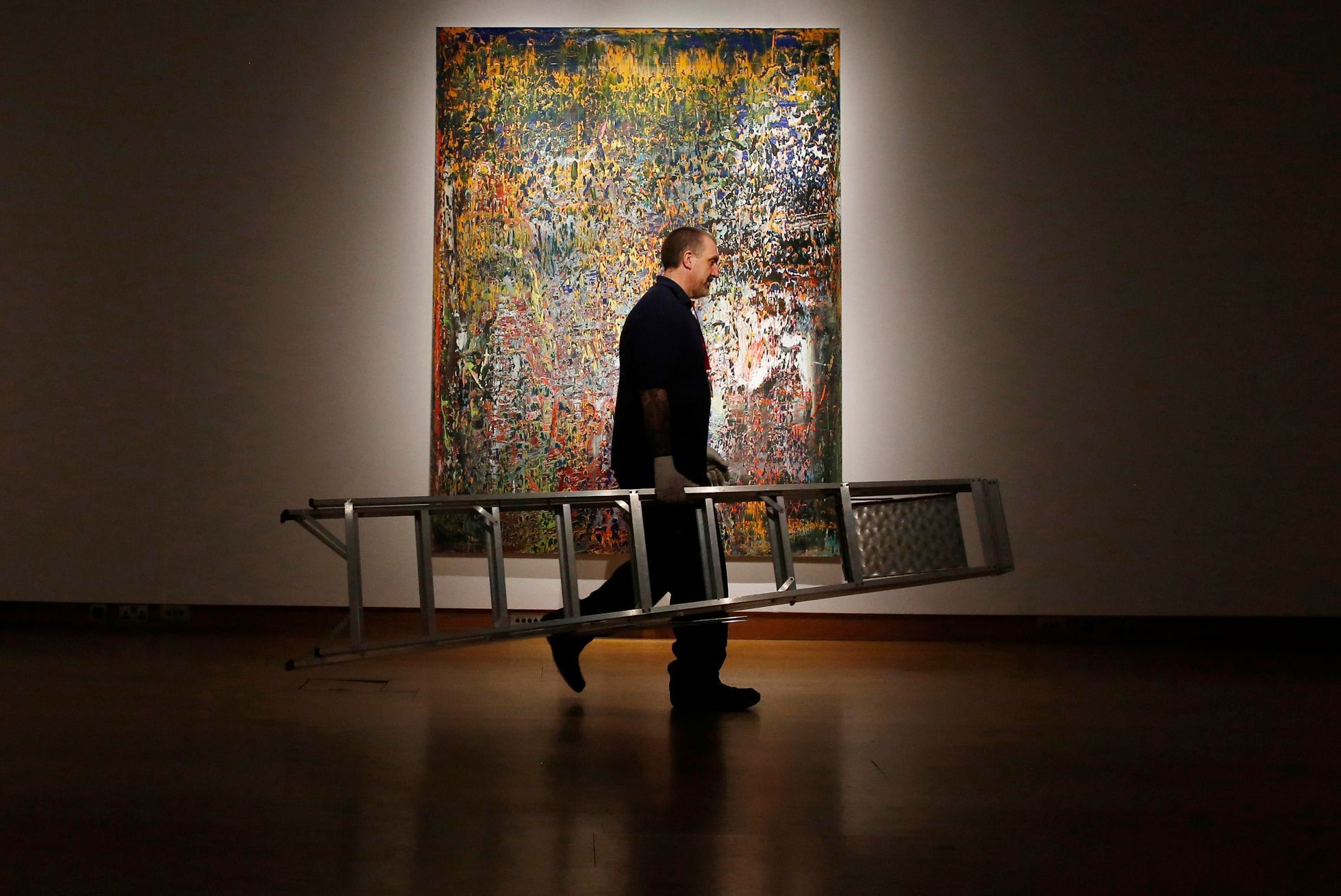 A man carries a ladder past &quot;Abstraktes Bild&quot; by Gerhard Richter in 1989  on display at Christie's in London