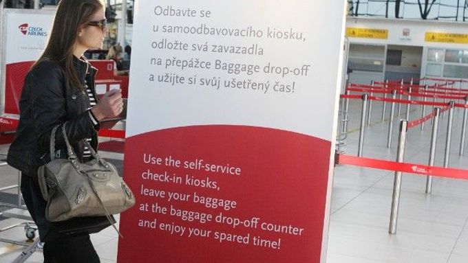 Informační tabule na ruzyňském letišti lákají cestující k samoodbavovacím kioskům.
