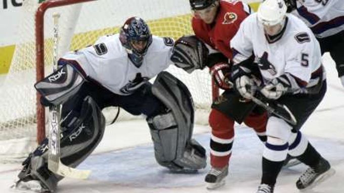 Hokejista Vancouveru Canucks Luákš Krajíček (vpravo) a Antoine Vermette z Ottawy Senators (uprostřed) bojují o puk před gólmanem Canucks Robertem Luongem.