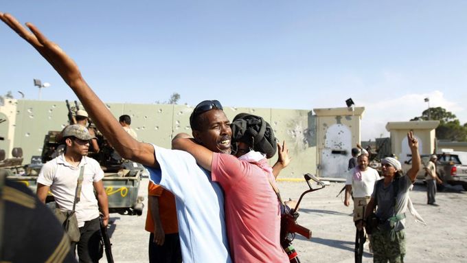 Povstalci oslavují dobytí Kaddáfího pevnosti Báb Al-Azízíja.
