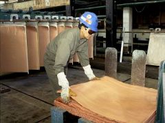 Dělník ukládající plát mědi v továrně společnosti Phelps Dodge.