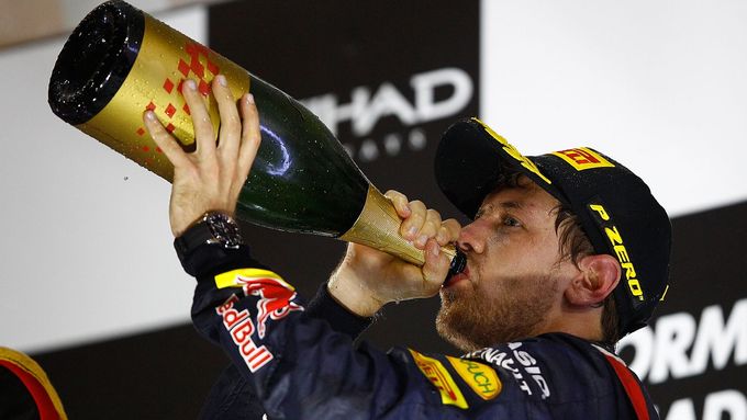 Sebastian Vettel si užívá šampaňského na stupních vítězů v Abú Zabí.
