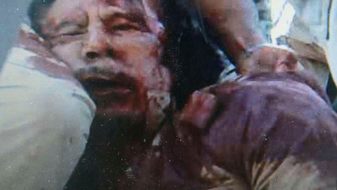 Těžce zraněný Kaddáfí v rukou povstalců.