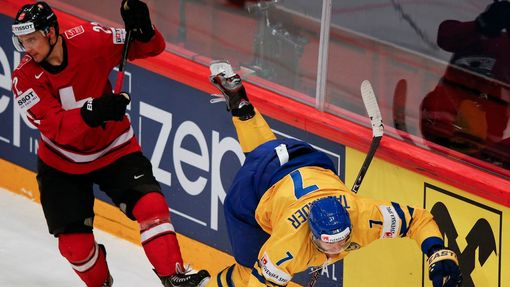 Switzerland's Nino Niederreiter fights for the puck with Sweden's Henrik Tallinder (R) during their 2013 IIHF Ice Hockey World Championship final match at the Globe Arena