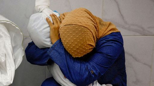 Palestinka Inas Abu Maamar, 36 let, objímá tělo své pětileté neteře Saly, která byla zabita při izraelském útoku, v nemocnici Nasser v Chán Júnisu.
