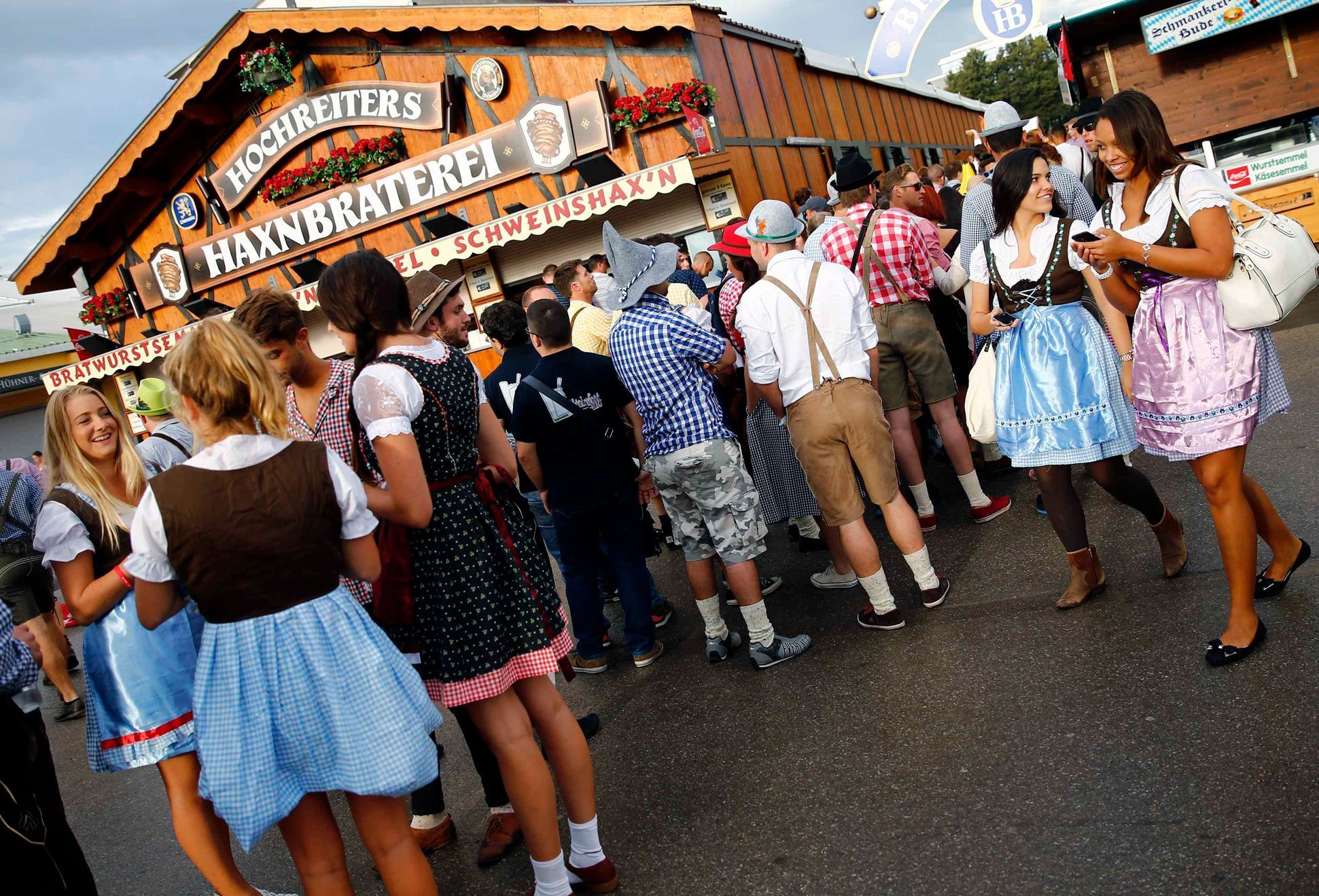Návštěvníci 181. Oktoberfestu v tradičních krojích čekající před pivním stanem v Mnichově.