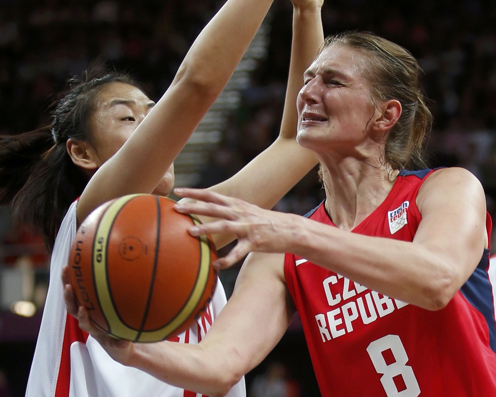 Česká basketbalistka Ilona Burgrová se snaží prorazit obranu Číňanky Song Gaové v turnaji OH 2012 v Londýně.