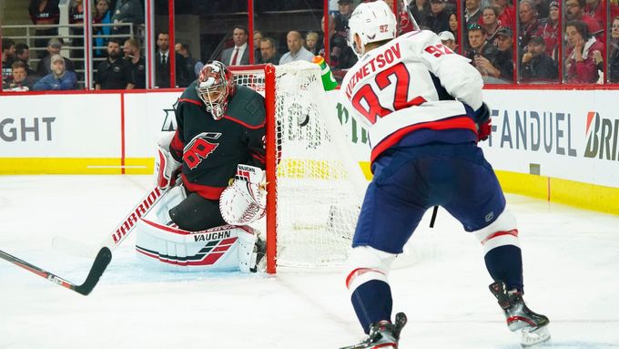 Brankář Caroliny Petr Mrázek zasahuje v utkání 1. kola play off NHL proti pokusu Jevgenije Kuzněcova z Washingtonu
