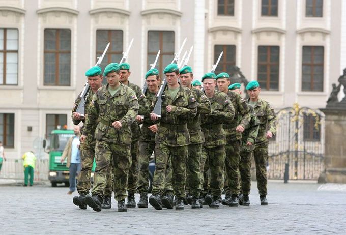 Vojáci Hradní stráže pochodují po Hradčanském náměstí.