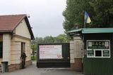 Uniformovaní muži kontrolují vstupenky u vchodu do areálu bývalého sídla ukrajinského exprezidenta.