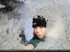Běloruský chlapec za zamrzlým oknem autobusu v Minsku