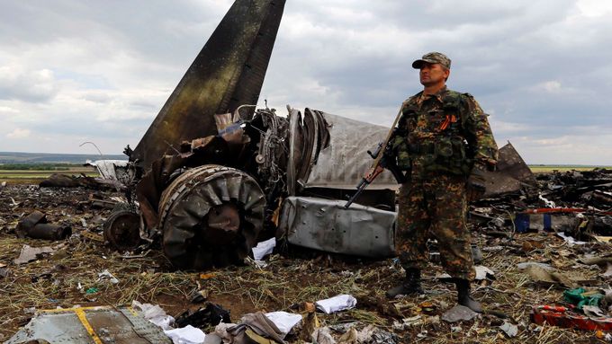 Ozbrojená stráž u sestřeleného letadla Il-76 ukrajinské armády. Trosky hlídá separatista.