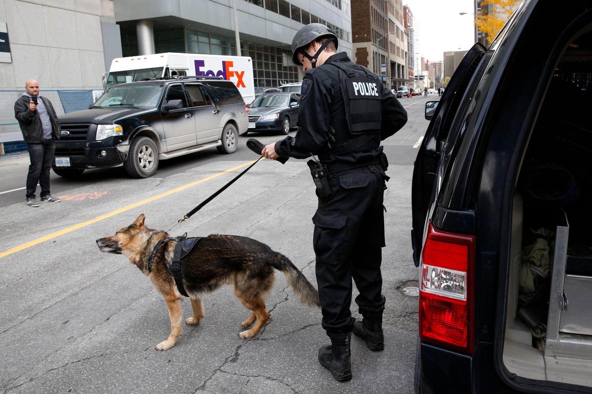 A Ottawa police officer prepares a service dog following shooting incidents in downtown Ottawa