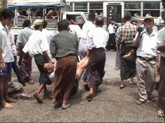 Civilní milice odtahují účastníka pouliční demonstrace v rangúnské čtvrti Hledan do přistaveného vozu