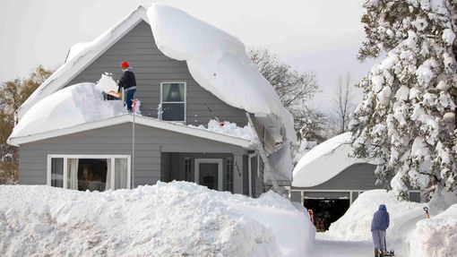 Obyvatelé odstraňují hromady sněhu nejen z chodníků, ale i ze střech svých domů (Buffalo v New Yorku)