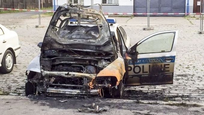 Policejní auto zapálené uskupením Síť revolučních buněk.