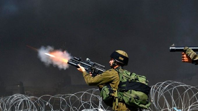Izraelští vojáci střílejí slzný plyn na palestinské demonstranty u checkpointu Kalandíja nedaleko Ramalláhu.