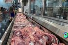 Muž stojí u zásob vepřového masa na skladě v americkém státě Texas.