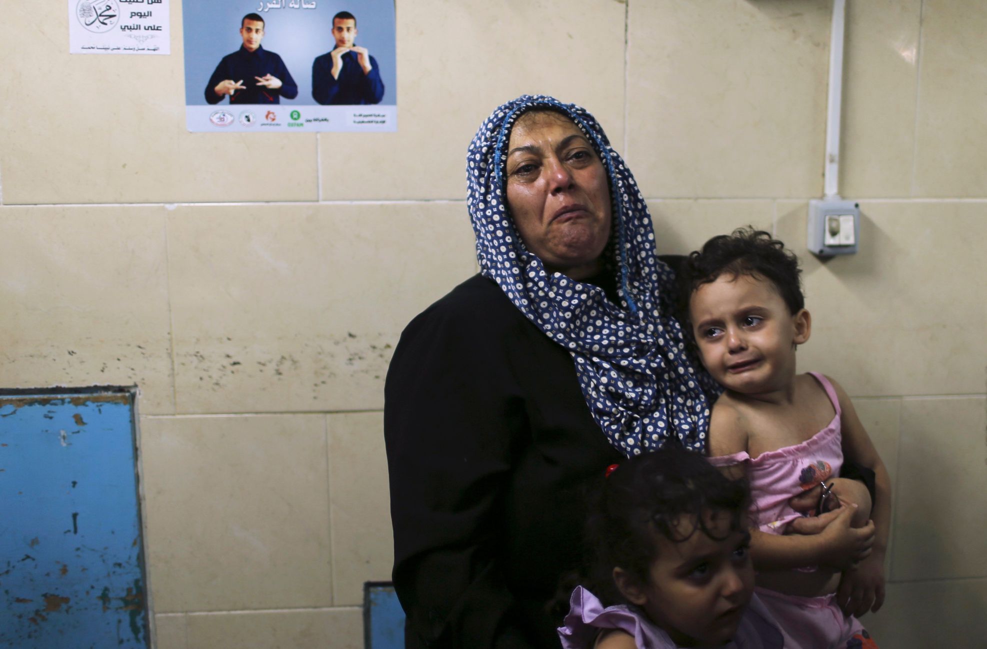 Relatives of Palestinians, whom hospital officials said were wounded by Israeli air strike, cry at hospital in Gaza City