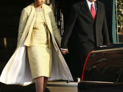 Prezidentský pár opouští tzv. Blair House, odkud před inaugurací zamířili na dopolední bohoslužbu. Michelle Obamová zvolila pro slavnostní příležitost nápadný žlutý kostým.