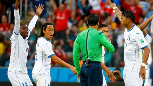 Honduras players argue with referee Sandro Ricci of Brazil after a controversial goal decision during their 2014 World Cup Group E soccer match against France at the Beir