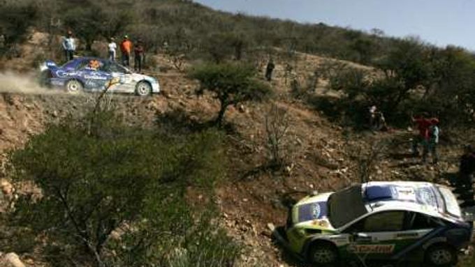 Gabriel Pozzo s Mitsrubihi projíždí kolem rozbitého Fordu finského jezdce Mikky Hirvonena.