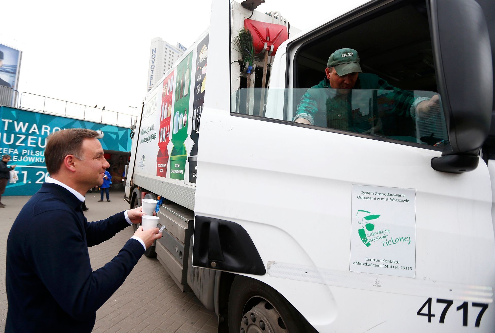 Andrzej Duda podává kávu řidiči nákladního auta s odpadky ve Varšavě.