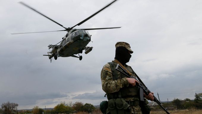 Ukrajinský voják a helikoptéra ve městě Novoajdar nedaleko fronty v Luhanské oblasti.