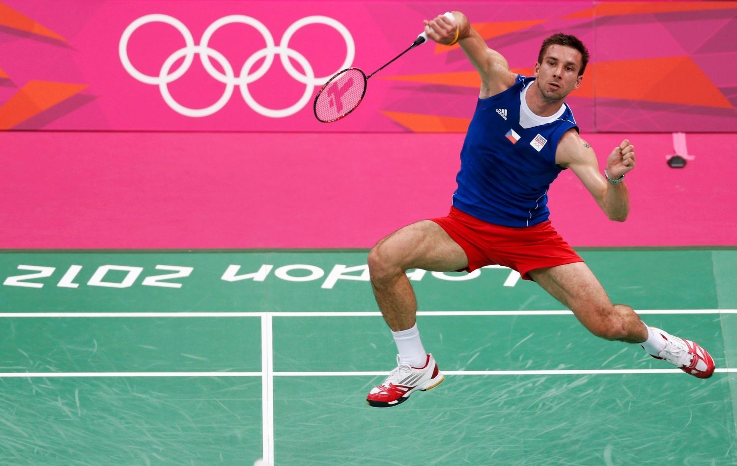 Český badmintonista Petr Koukal hraje utkání se Španělem Pablo Abianem na OH 2012 v Londýně.