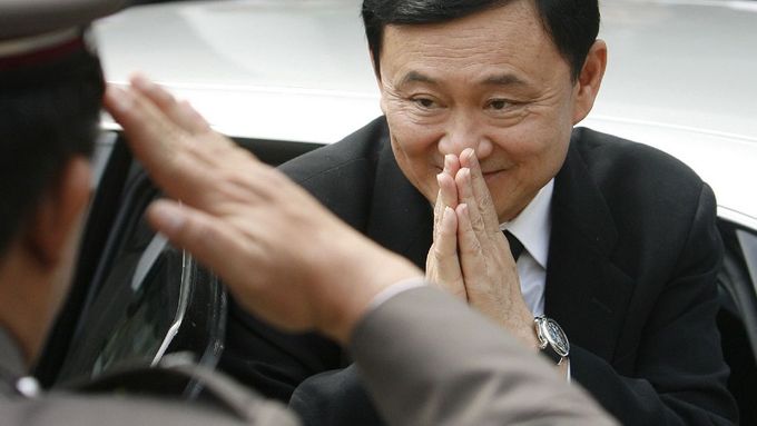 Thaksin před budovou Nejvyššího soudu zdraví stráž tradičním thajským gestem wai, vyjadřujícím respekt i absenci zlých úmyslů. Ne všichni mu demonstrovanou pokoru věří