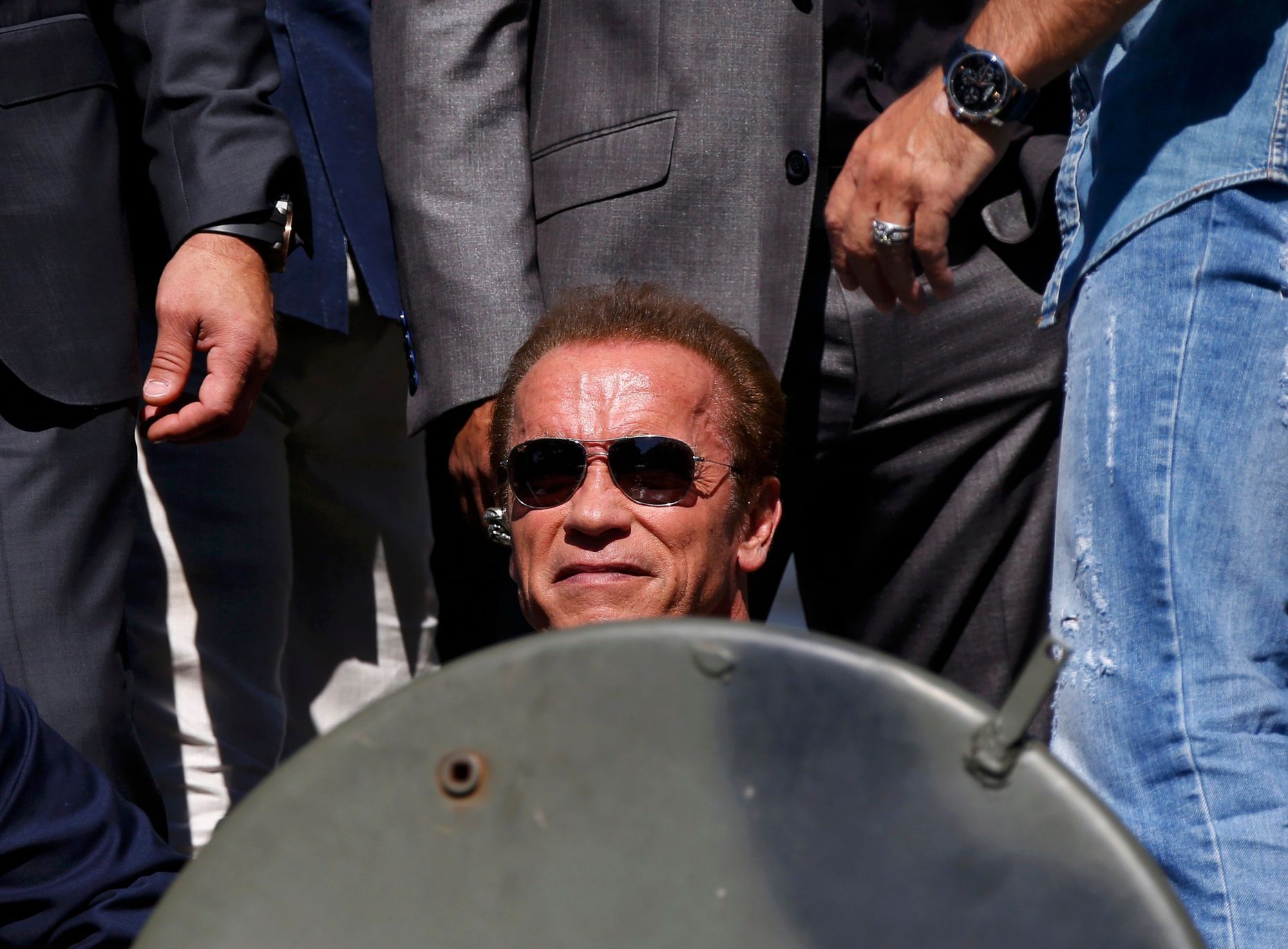 Cast member Arnold Schwarzenegger poses on a tank as they arrive on the Croisette to promote the film &quot;The Expendables 3&quot; during the 67th Cannes Film Festival in Cannes