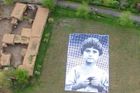 Piloty dronů má obměkčit obří portrét dítěte v polích