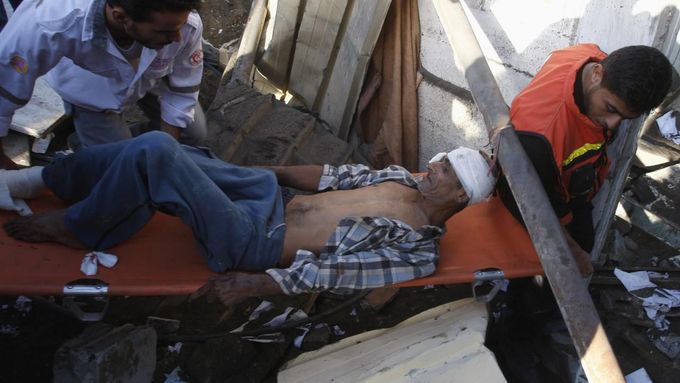 Palestinci vynášejí muže evakuovaného z trosek jeho domu v pásmu Gazy