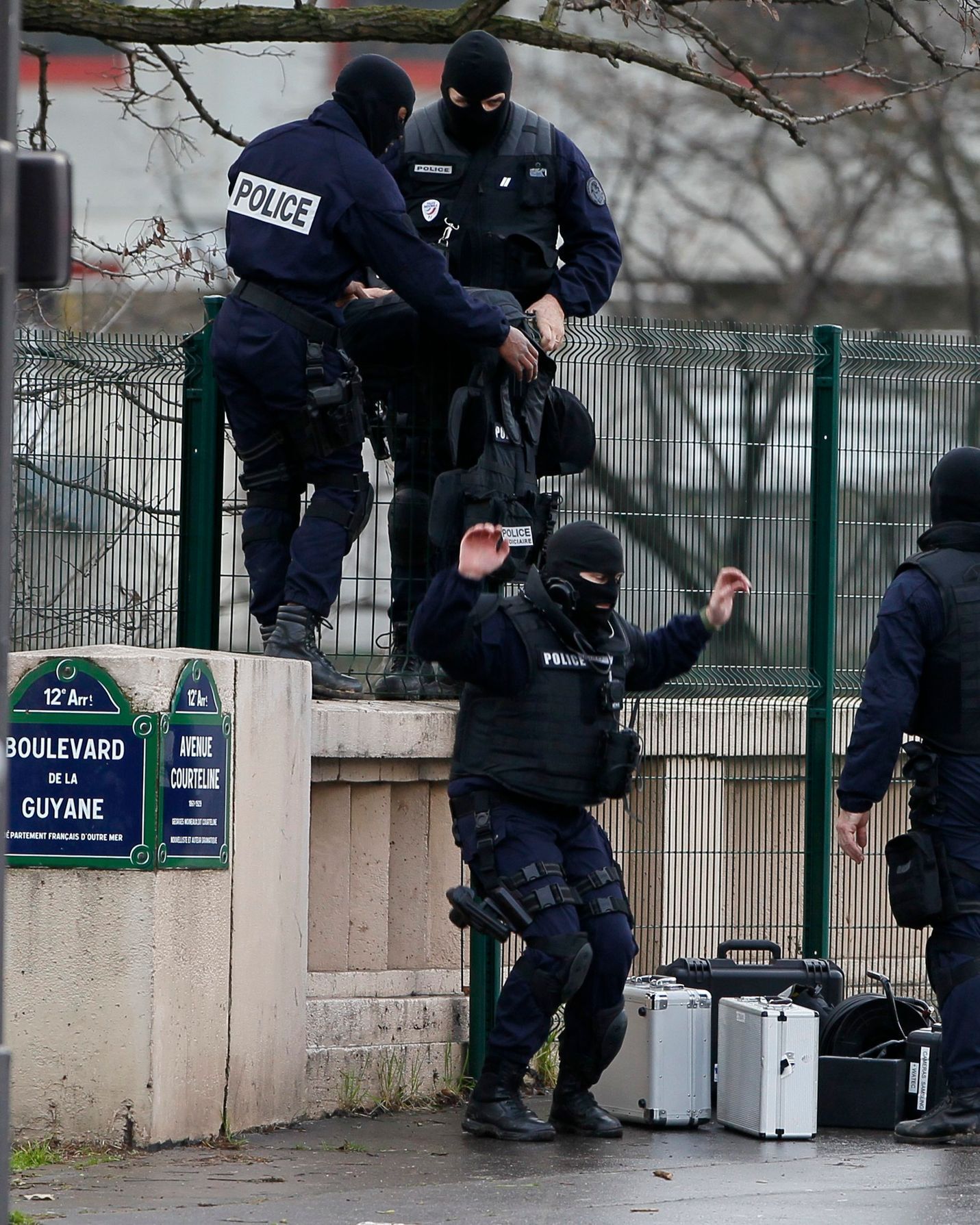 Members of the French police special force advance with their equipment near the scene of a hostage taking at a kosher supermarket in eastern Paris