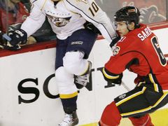 Martin Erat z Nashville Predators se snaží přeskočit hůl Coryho Saricha z Calgary Flames.