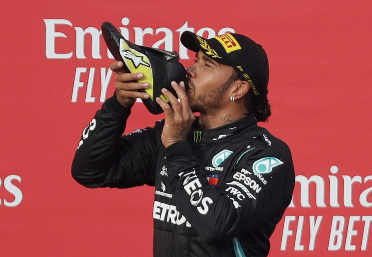 Lewis Hamilton pije z boty Daniela Ricciarda po závodě F1 v Imole