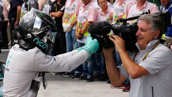 Nico Rosberg žertuje s kameramanem po vítězství ve Velké ceně Brazílie.